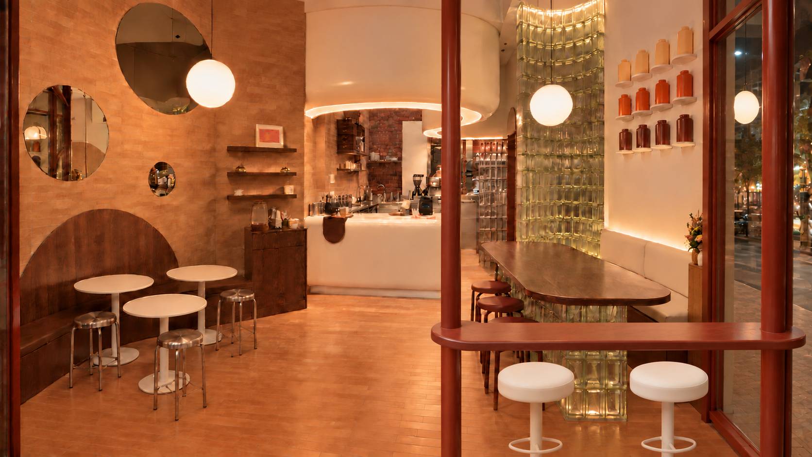 Inside CHONG: terracotta tile wall with round mirrors, white tables and stools, a cream service counter, glass-block column and a communal wood table.