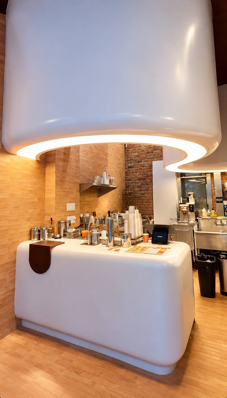 Cream rounded service counter under a curved ceiling with warm light, in front of a tile wall.