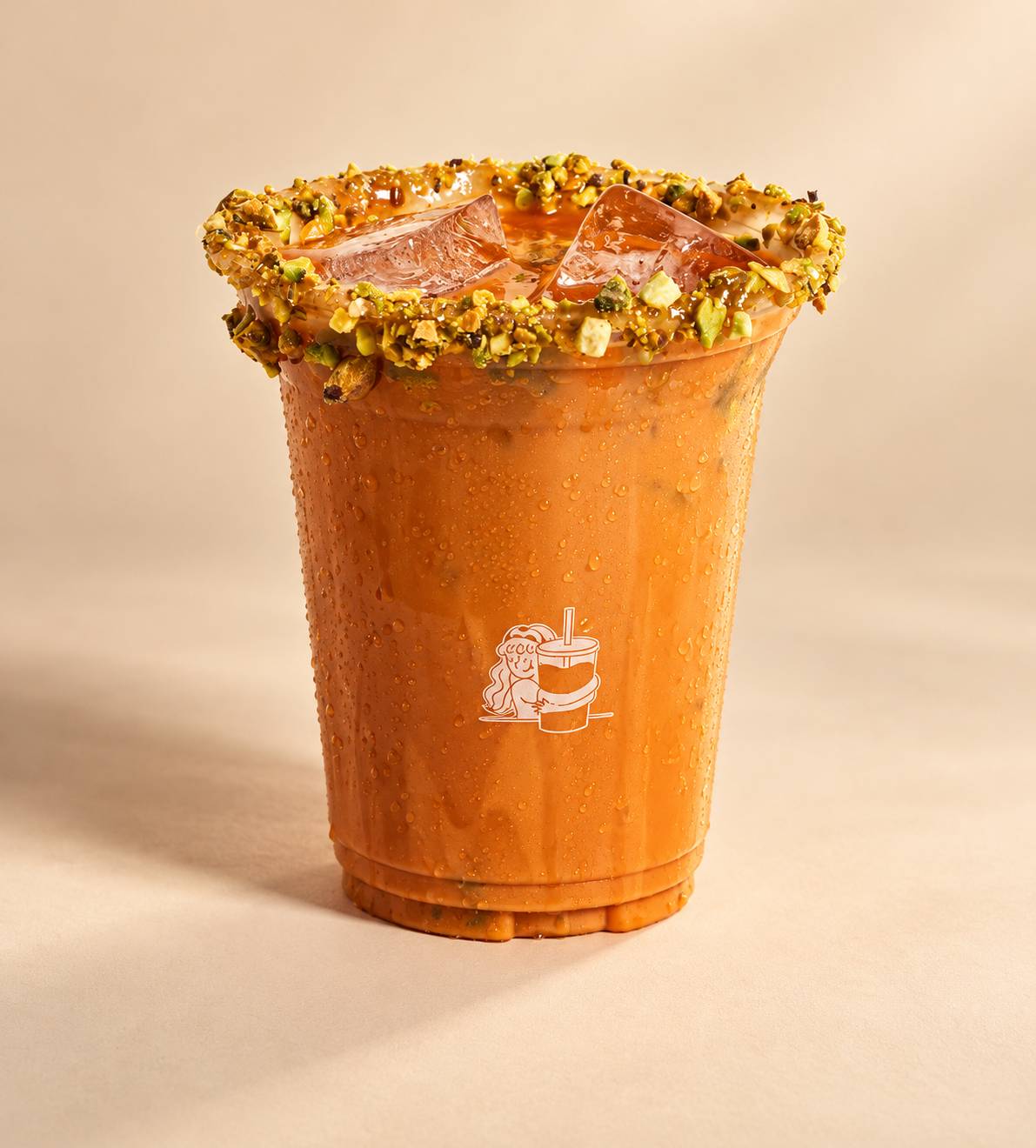 Orange iced tea over ice in a clear cup with a green crumb-coated rim.
